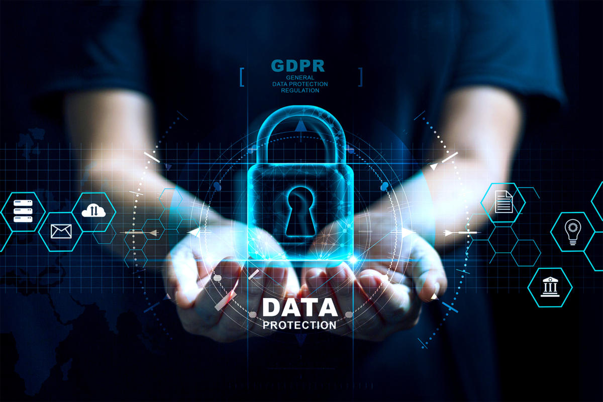  A person is holding a glowing blue padlock in the palm of their hand with 'Data Protection' written below it, surrounded by a dark background with various icons and the words 'GDPR' and 'General Data Protection Regulation'.